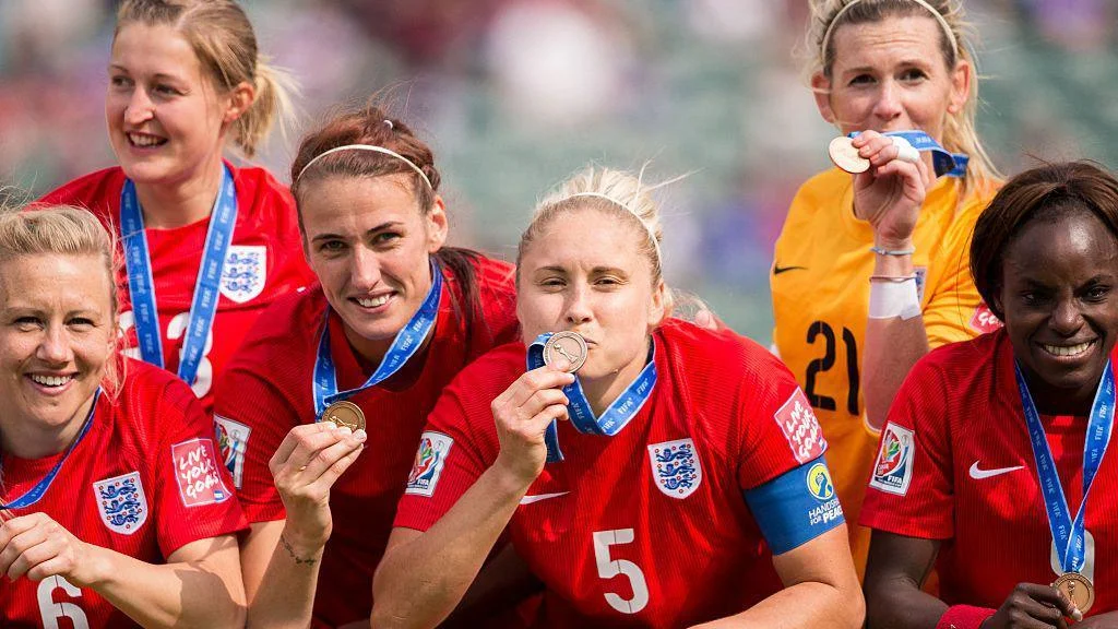 England women's players pose with their bronze medals after beating Germany in the World Cup 2015 third-place play-off